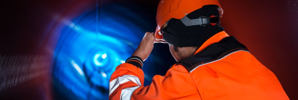 Worker in full PPE entering a confined space during HSE safety training in Saudi Arabia